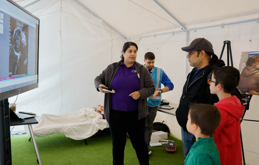 An LSC staff member shows guests an ultrasound via the Pulsenmore device