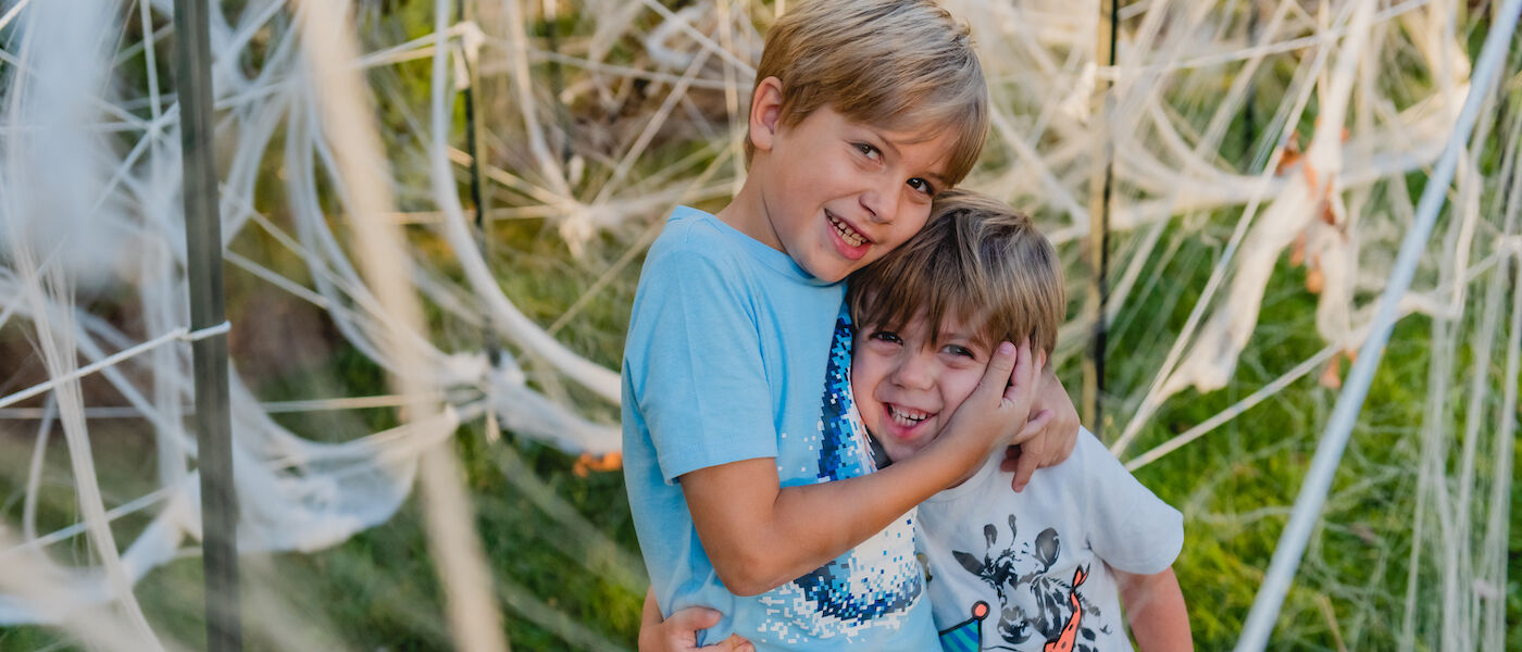 Two boys hugging in Spider Maze