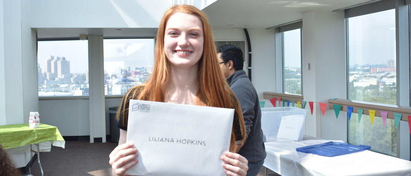 Teen Summer Docent volunteer Liliana Hopkins holds up her certificate