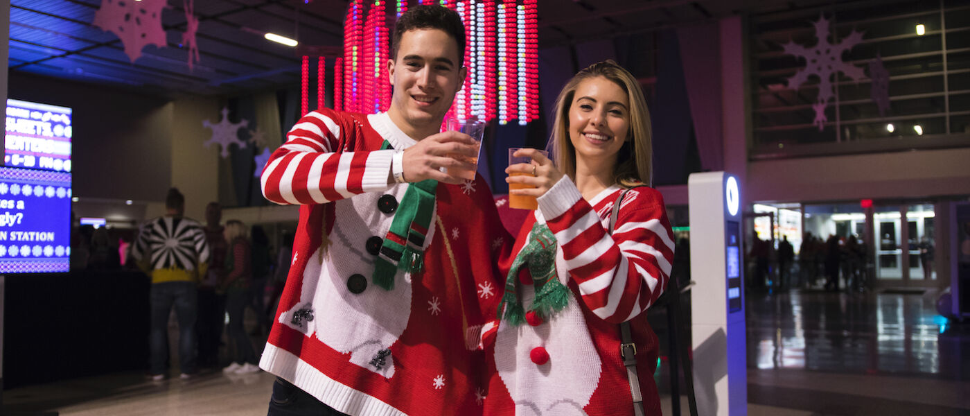 Man and woman wearing connected holiday ugly sweater
