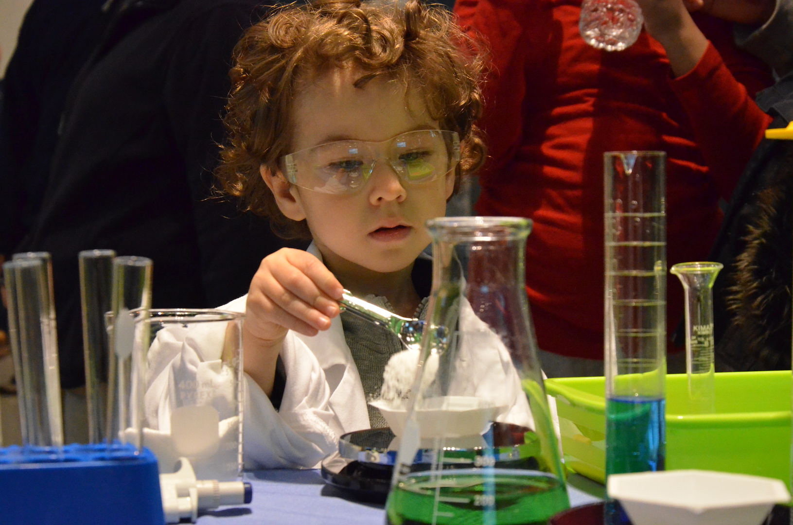 Boy doing science experiment while wearing lab coat