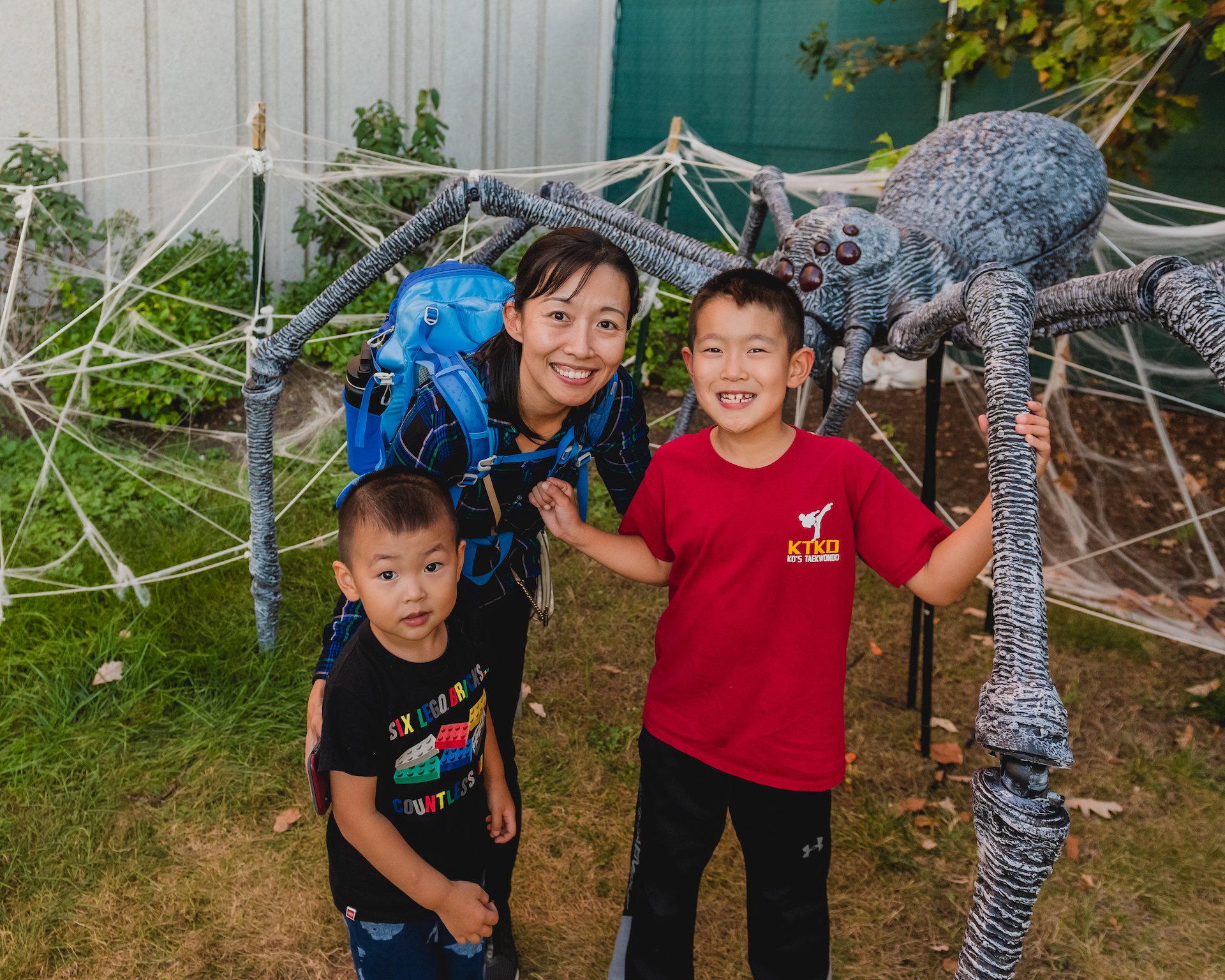 Family posing with giant crab spider in Spider Maze