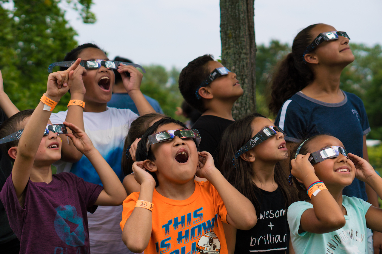 Guests watch the eclipse with solar viewing glasses